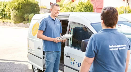 Zwei Mitarbeiter und das Fahrzeug der R Geissmann AG